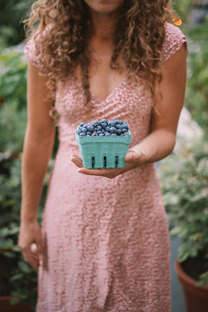 woman holding carton of blueberries