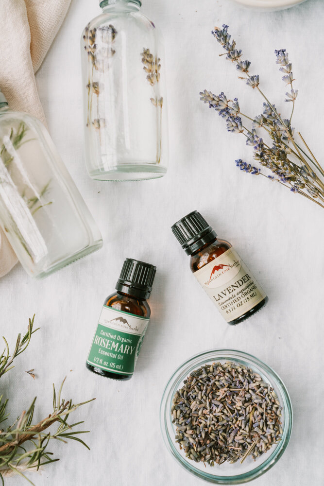 best essential oils for cleaning on a linen backdrop surrounded by lavender