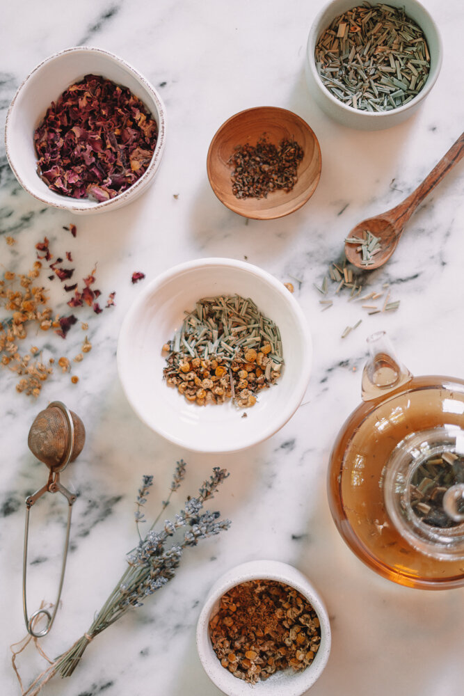 overhead view of the best herbal tea recipes with tea and herbs in small bowls
