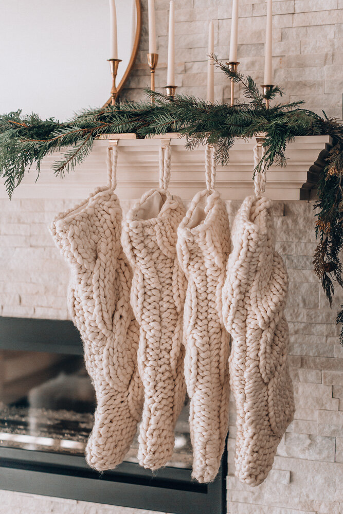 mantel with white knit stockings and greenery