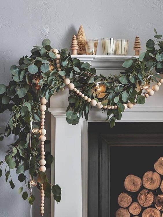eucalyptus and wooden bead garland over a fireplace mantel