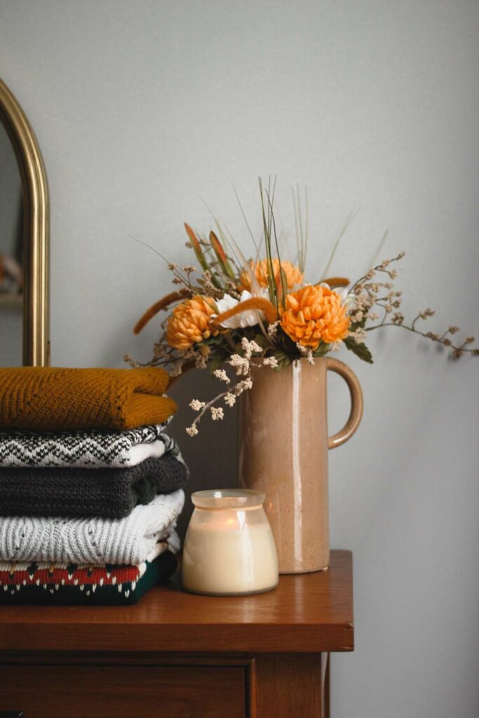 sweaters on a dresser with flowers