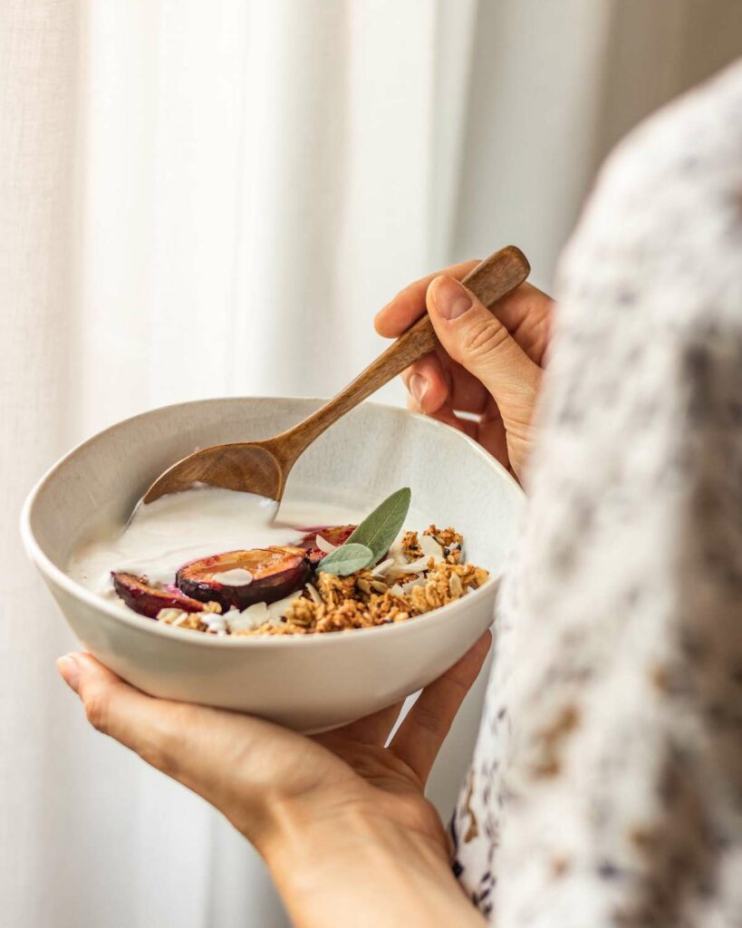 woman holding bowl of yogurt immune support supplement and wellness routine