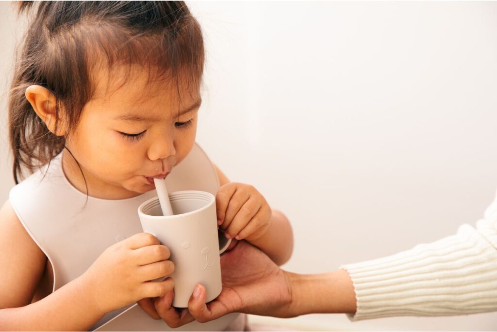 toddler drinking from a straw cup